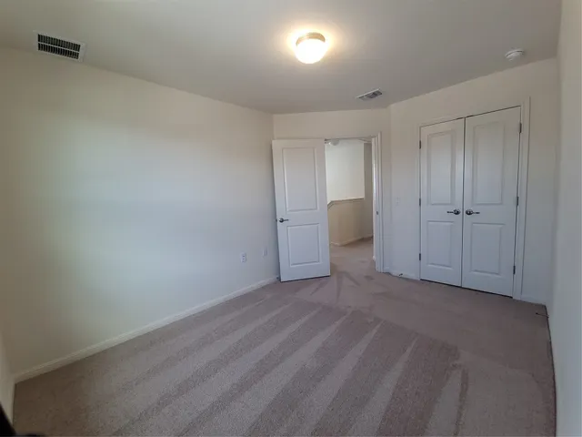 a view of an empty room and closet area