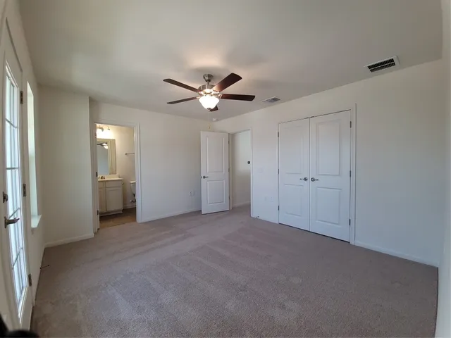 a view of a livingroom with a ceiling fan window and closet