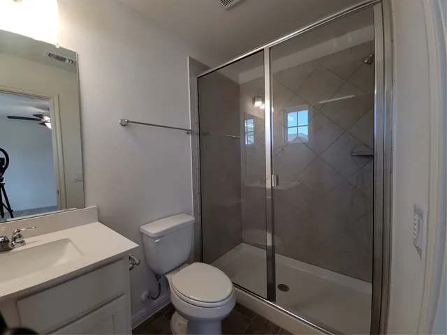 a bathroom with a shower a toilet and sink