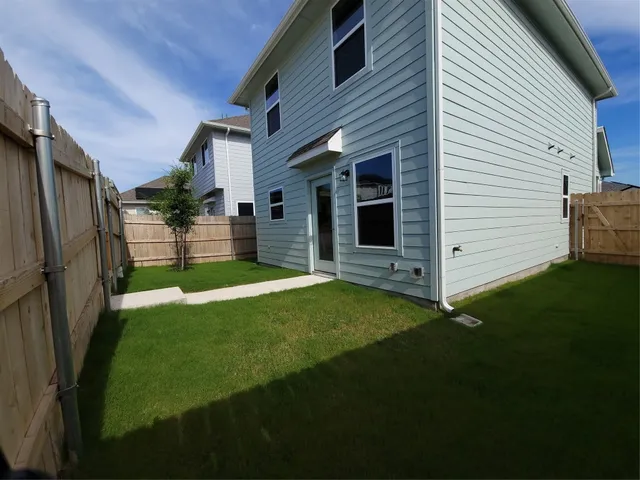 a view of a house with backyard and a tree