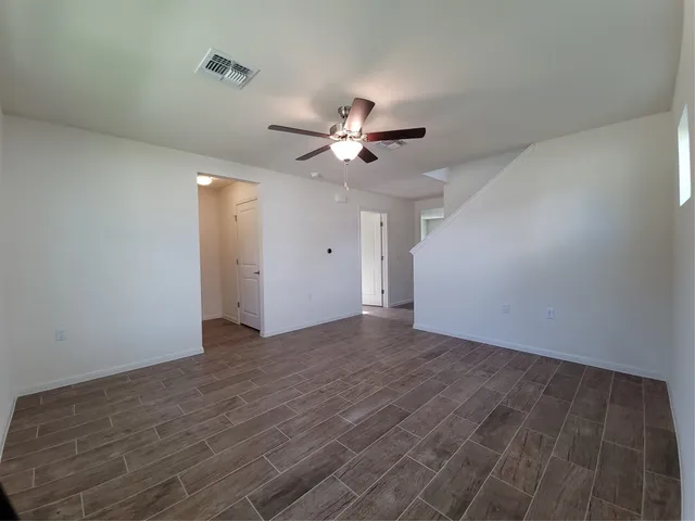 a view of an empty room with a ceiling fan