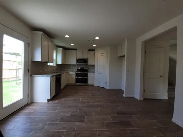 a kitchen with stainless steel appliances granite countertop a refrigerator and a stove top oven