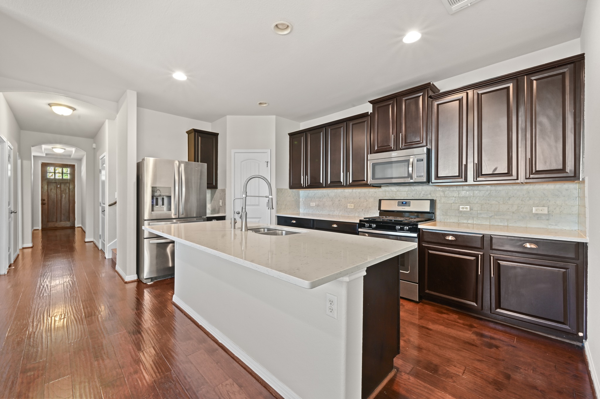 351 Wincliff Drive Buda, TX 78610 - Photo 17 of 40 A gourmet kitchen offers rich cabinetry, stainless steel appliances, and a central island with a deep sink.
