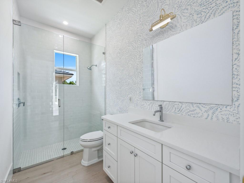 Undisclosed Address Naples, FL 34110 - Photo 13 of 27 a bathroom with a granite countertop sink a toilet and a shower
