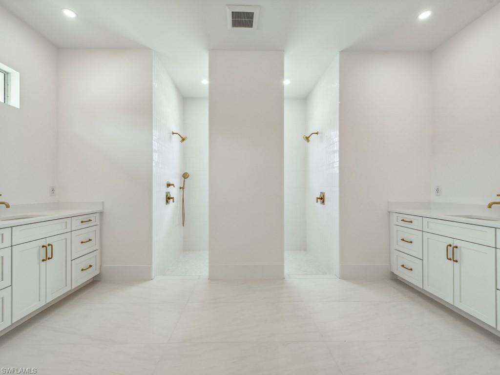 Undisclosed Address Naples, FL 34110 - Photo 16 of 27 a bathroom with a granite countertop sink two mirror and a bathtub