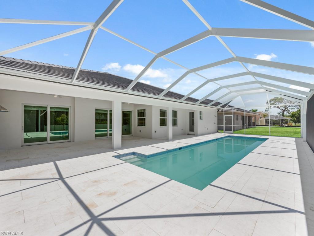 Undisclosed Address Naples, FL 34110 - Photo 21 of 27 a front view of a house with a yard and potted plants