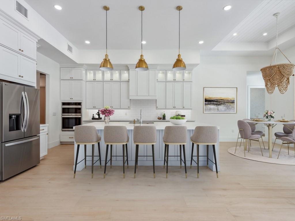 Undisclosed Address Naples, FL 34110 - Photo 6 of 27 a open kitchen with white cabinets and stainless steel appliances