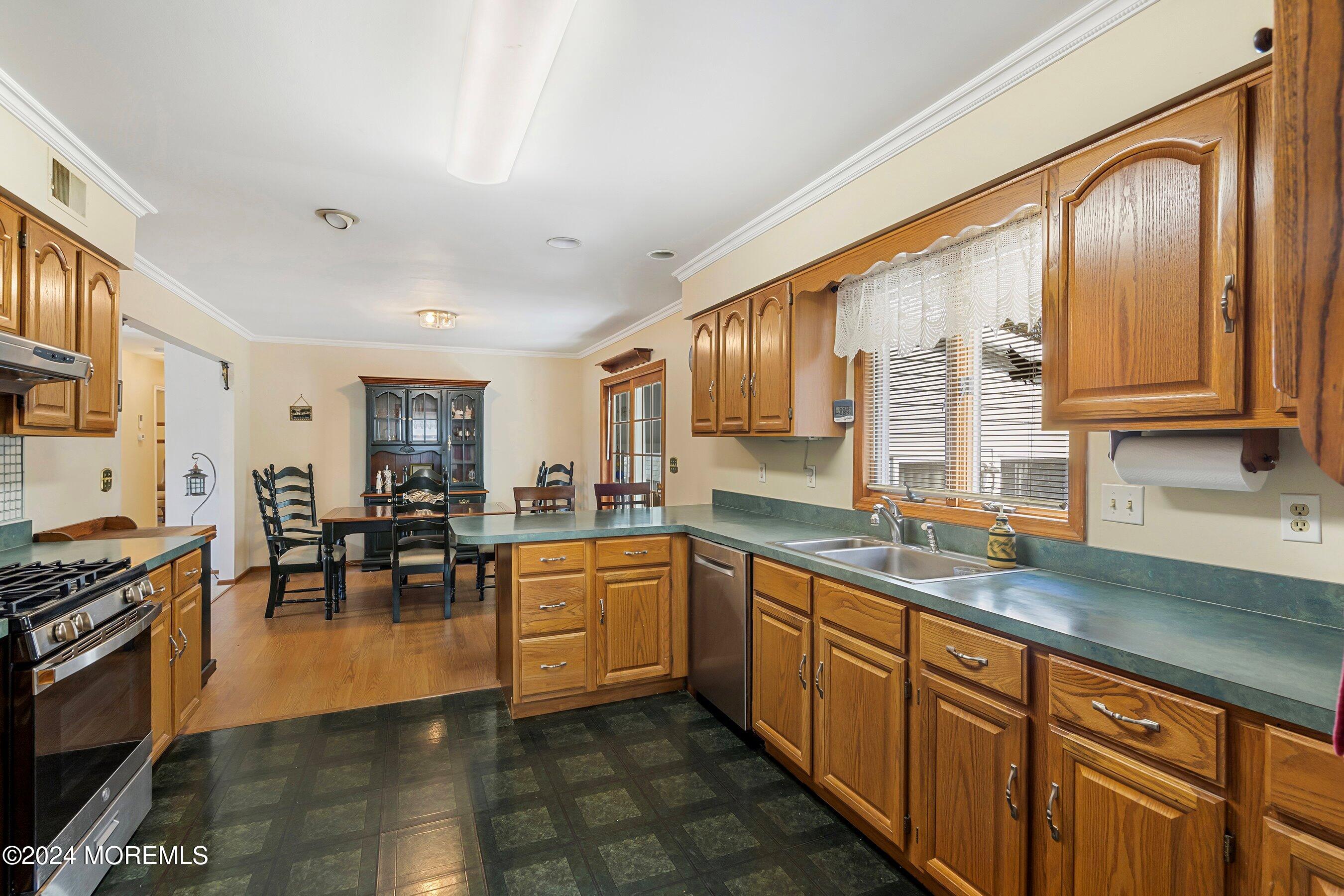 305 Bayside E Parkway Forked River, NJ 08731 - Photo 21 of 39 a open kitchen with stainless steel appliances granite countertop a stove top oven a sink dishwasher a dining table and chairs with wooden floor