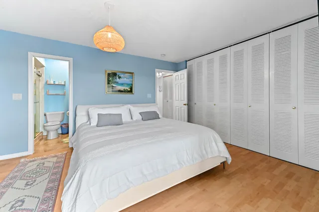 a bedroom with a bed and painting on the wall