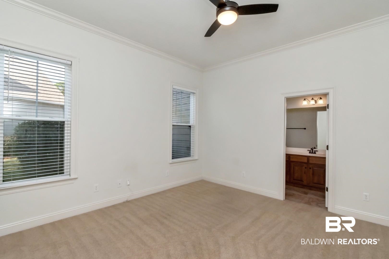 30585 Pine Court Daphne, AL 36527 - Photo 15 of 49 Unfurnished bedroom with light carpet, multiple windows, ceiling fan, ornamental molding, and ensuite bath
