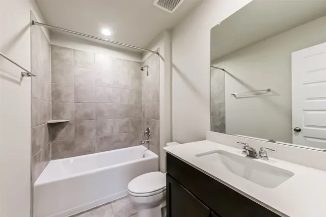 a bathroom with a bathtub shower sink mirror vanity and toilet