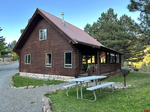 a view of a house with backyard and sitting area