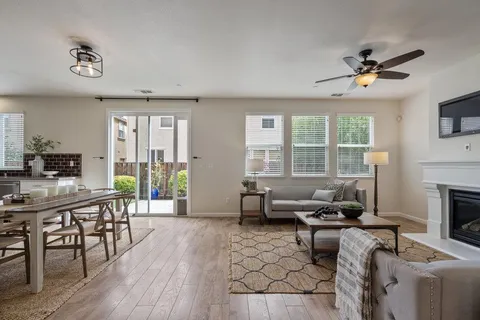 a living room with furniture a fireplace and a large window