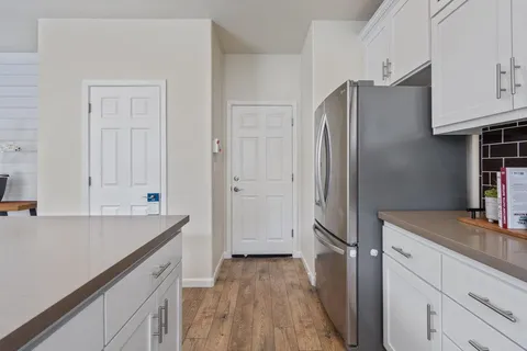 a kitchen with stainless steel appliances white cabinets a potted plant and a sink
