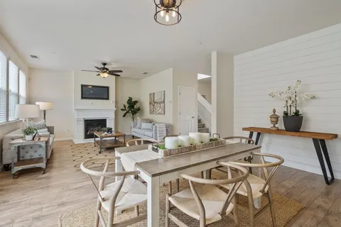 a view of a kitchen with kitchen island a counter top space a sink a stove and a refrigerator with wooden floor