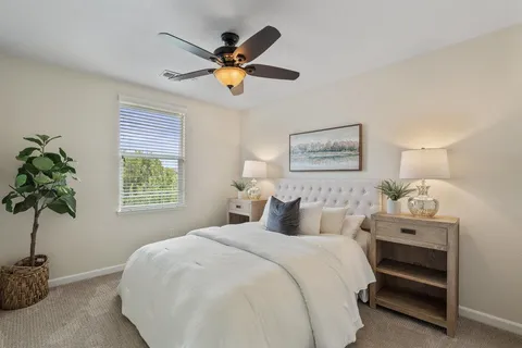 a bedroom with a bed and a potted plant