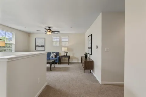a living room with furniture a ceiling fan a window and a window