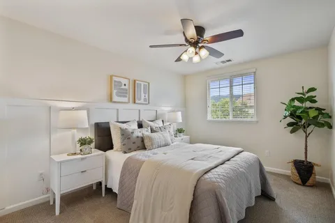 a bed room with a bed and a ceiling fan