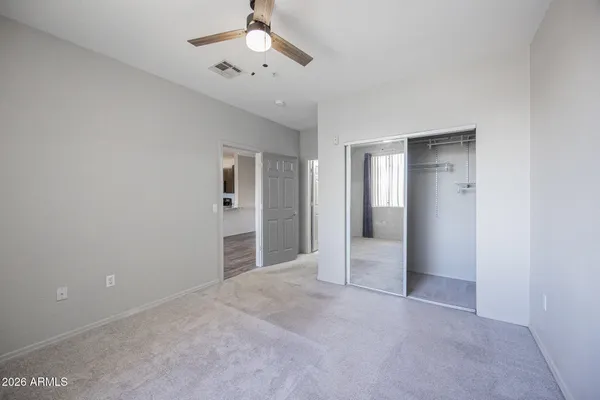 an empty room with closet and windows