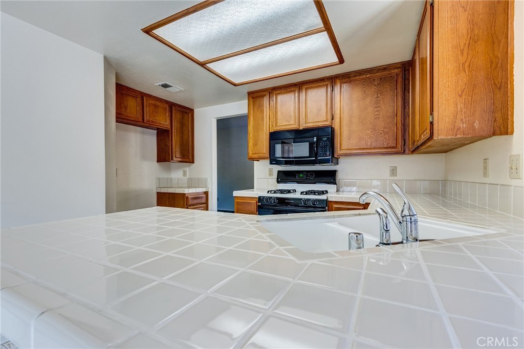 1922 Alta Street Redlands, CA 92374 - Photo 10 of 45 a kitchen with stainless steel appliances a stove a sink a microwave a refrigerator cabinets and a window