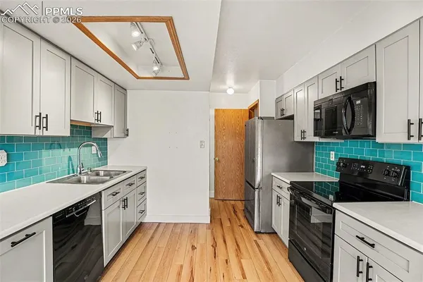 a kitchen with stainless steel appliances a stove sink microwave and cabinets