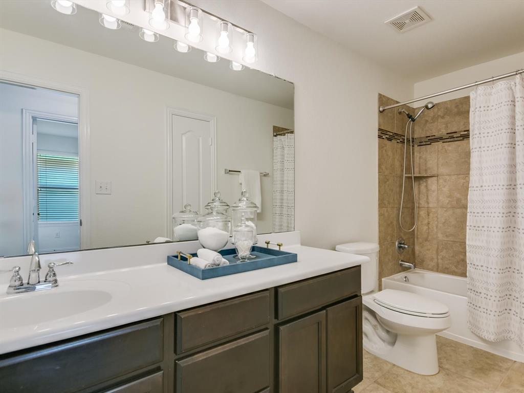 736 Bonnet Boulevard Georgetown, TX 78628 - Photo 16 of 27 a bathroom with a granite countertop sink toilet a mirror a vanity and shower