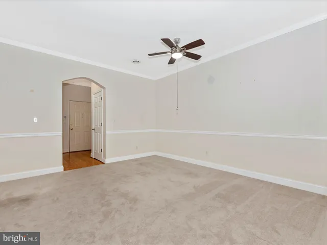 an empty room with a ceiling fan and a window