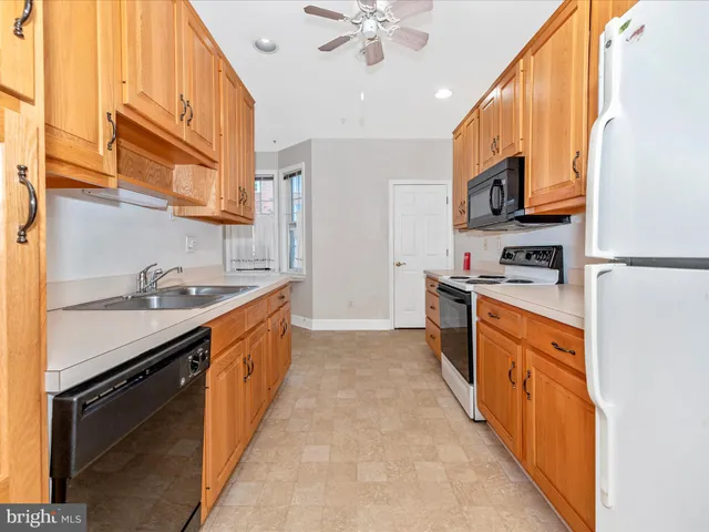 an empty room with a window and ceiling fan