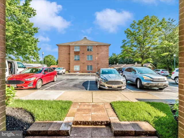 an empty room with windows and chandelier fan