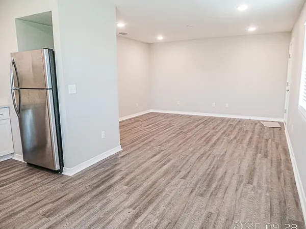 a view of kitchen space with wooden floor and refrigerator