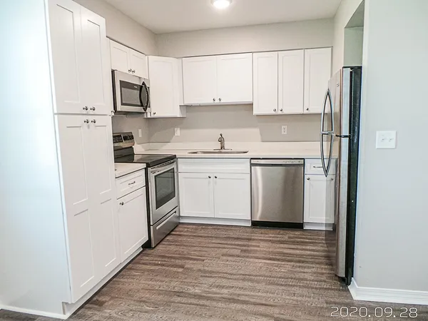 a kitchen with white cabinets stainless steel appliances and sink