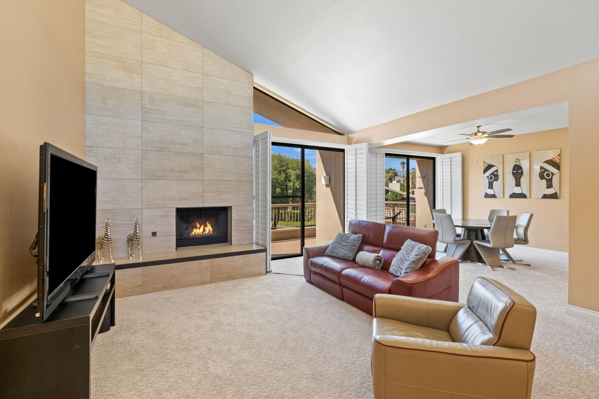 a living room with furniture a flat screen tv and a fireplace