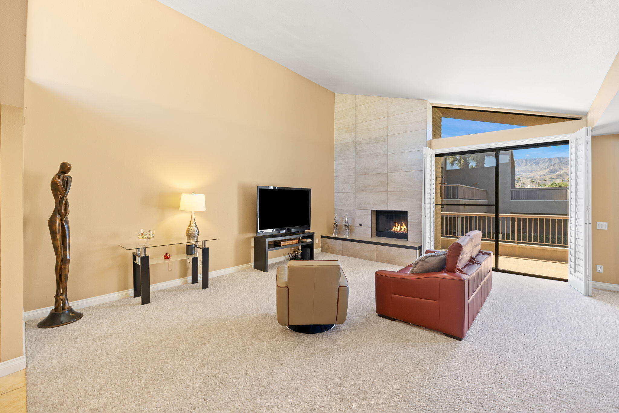 45775 Juniper Circle, Unit 616A Palm Desert, CA 92260 - Photo 2 of 35 a living room with furniture a flat screen tv and a fireplace