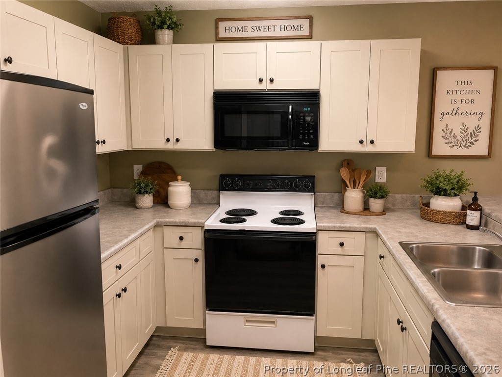 1833 Sardonyx Road, Unit 3 Fayetteville, NC 28303 - Photo 4 of 10 a kitchen with granite countertop white cabinets and white appliances