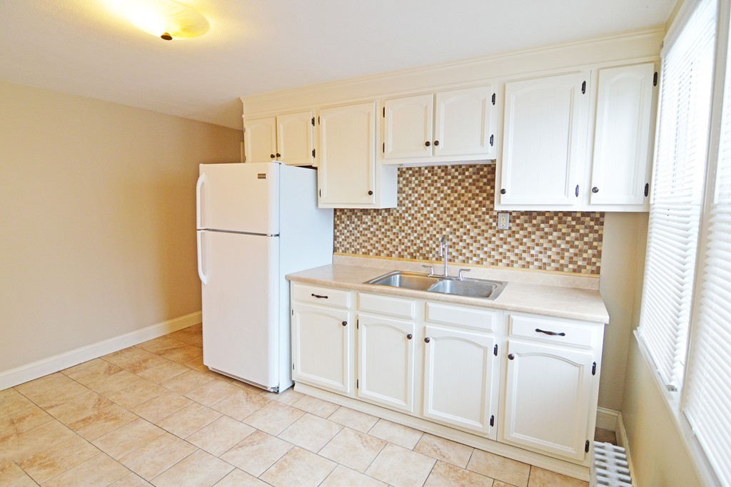 48-50 Jenness Street Springfield, MA 01104 - Photo 3 of 18 a kitchen with white cabinets and white appliances