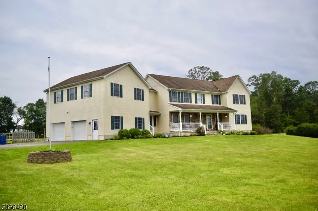 a front view of a house with a garden and trees