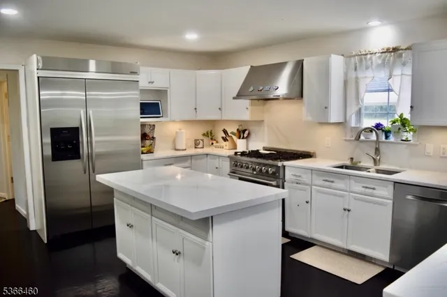 a kitchen with a sink stainless steel appliances and cabinets