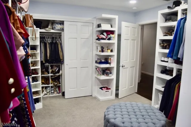 a view of walk in closet with clothes and shoes
