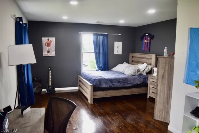 a bedroom with a bed and a lamp on dresser