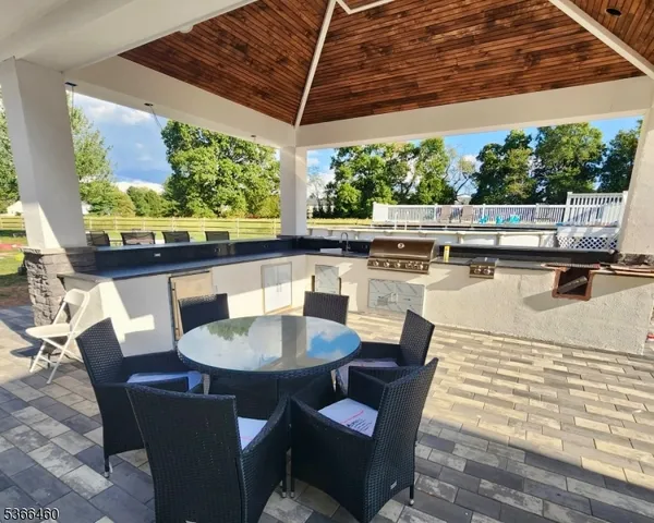 a view of a patio with a table chairs and a floor to ceiling window
