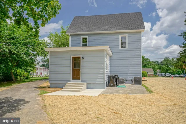 a view of a house with a yard and large tree