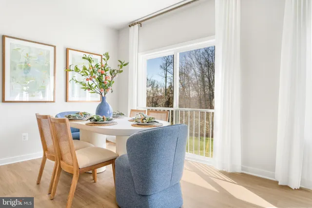 a view of a hallway with wooden floor and a bathroom