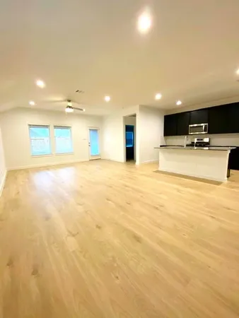 a large kitchen with stainless steel appliances kitchen island a large counter top a stove and a sink