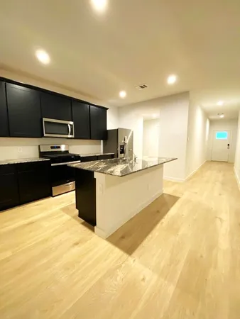 a kitchen with granite countertop a sink and a stove top oven