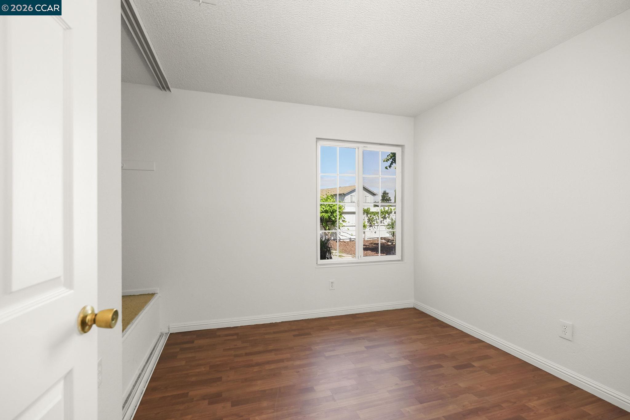 476 Pamela Drive Bay Point, CA 94565 - Photo 16 of 24 an empty room with window and wooden floor
