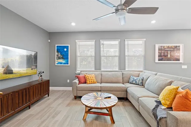 a spacious bedroom with a bed and a flat tv screen on dresser