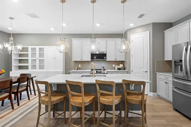 a kitchen with stainless steel appliances a stove a sink dishwasher a refrigerator oven and white cabinets next to a window