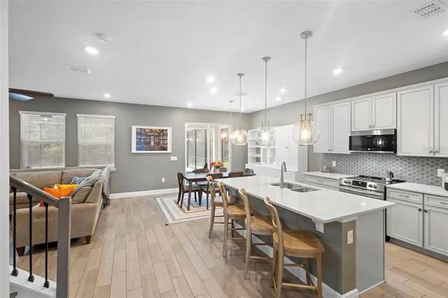 a kitchen with granite countertop a sink a counter space appliances and cabinets