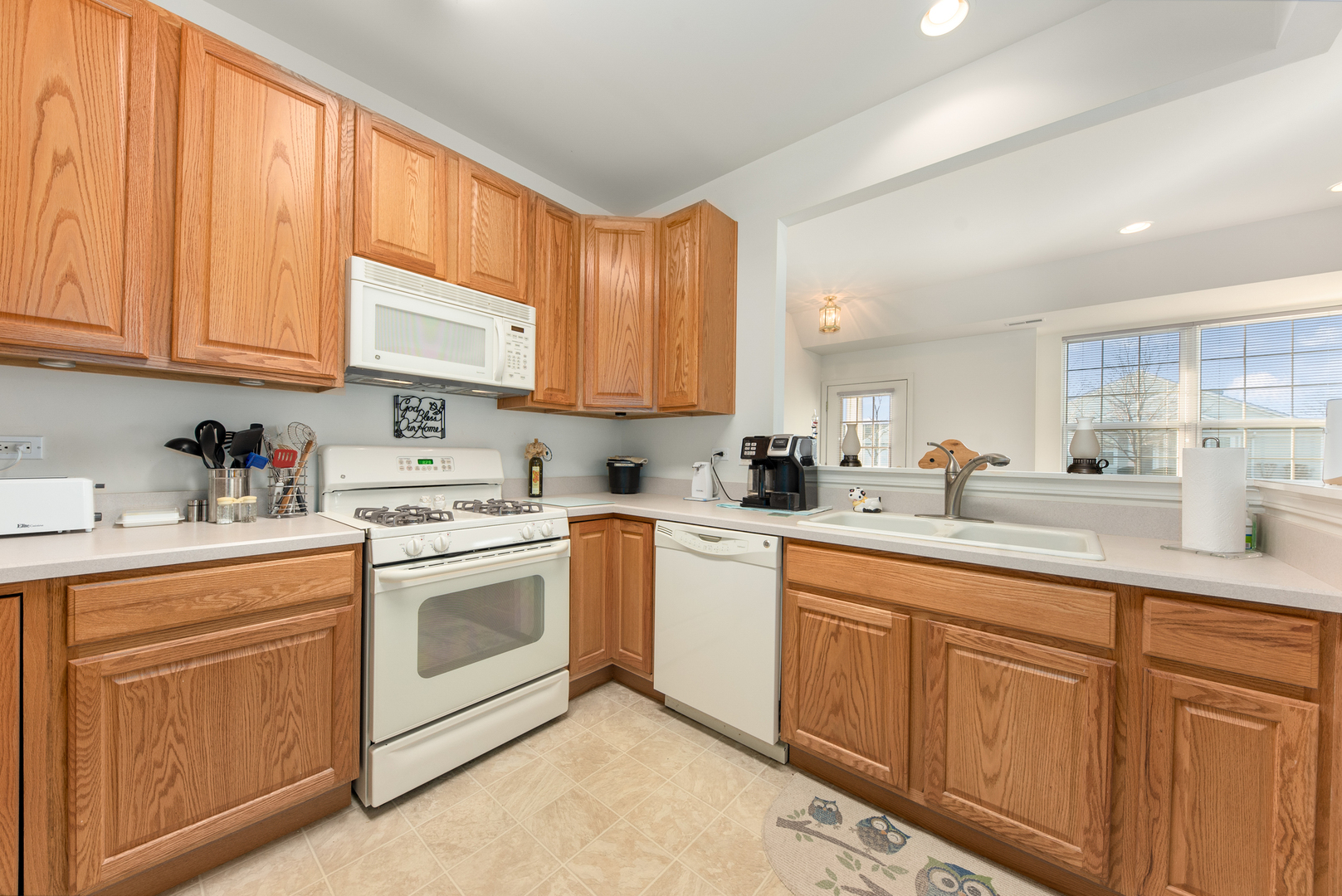 13512 Delaney Road Huntley, IL 60142 - Photo 6 of 24 a kitchen with granite countertop white cabinets sink and white appliances