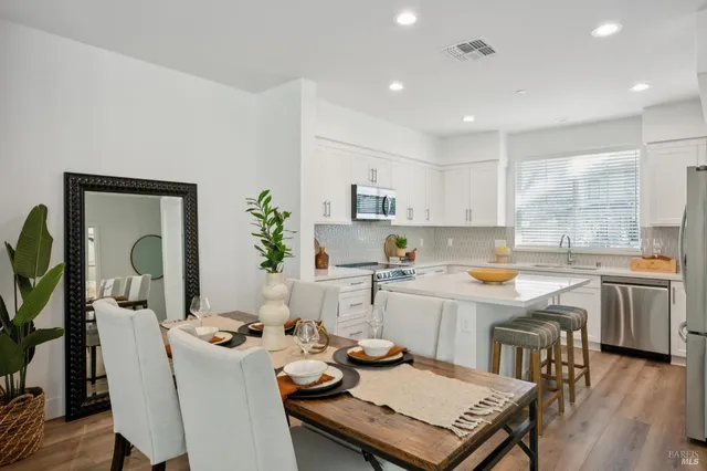 a kitchen with a table chairs stove and white cabinets